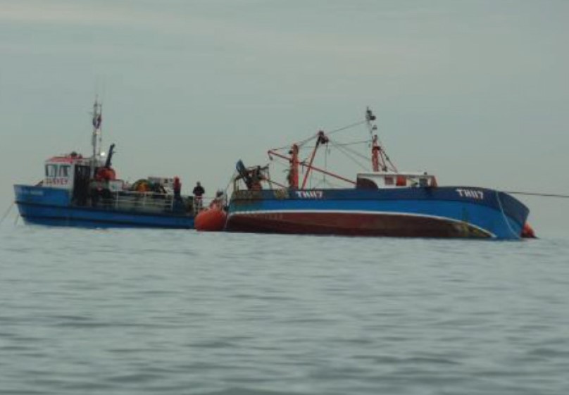 Tugboat by overturned boat
