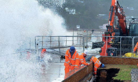 Waves batter workers at Teignmouth Sea Wall