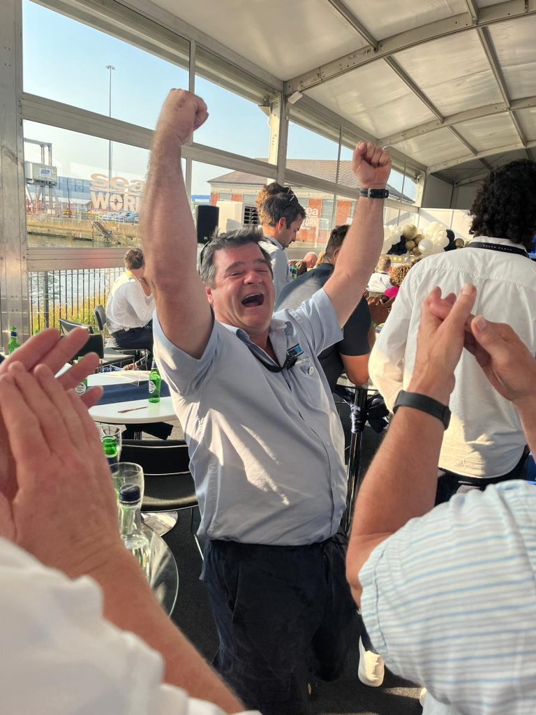 Man Cheering With Other Collegues